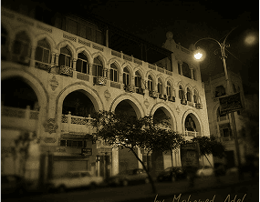 17)	Ornate, multi-arched building facade illuminated at night by streetlights.